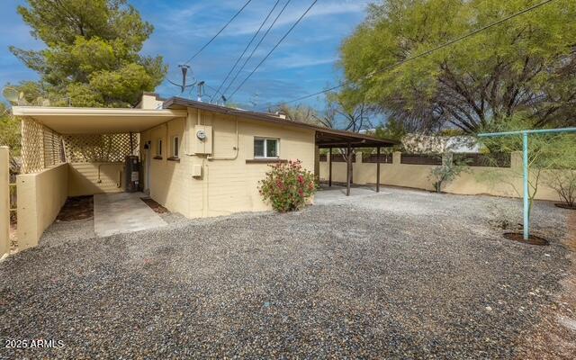 back of house featuring fence and an attached carport