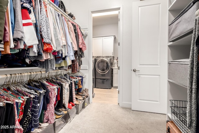 spacious closet featuring separate washer and dryer and carpet