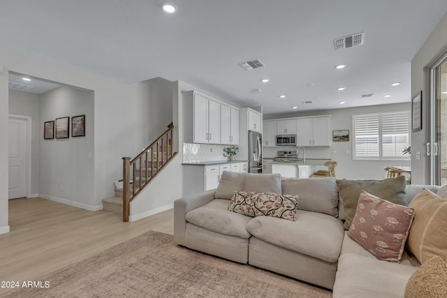 living room featuring sink and light hardwood / wood-style floors