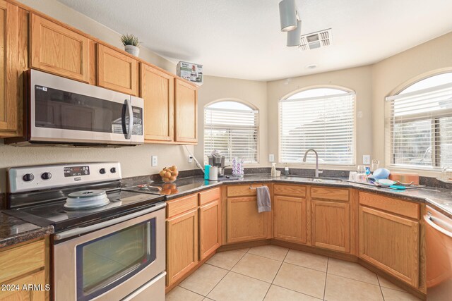 kitchen with light tile patterned flooring, sink, and stainless steel appliances