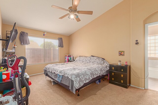 bedroom with light colored carpet, vaulted ceiling, multiple windows, and ceiling fan