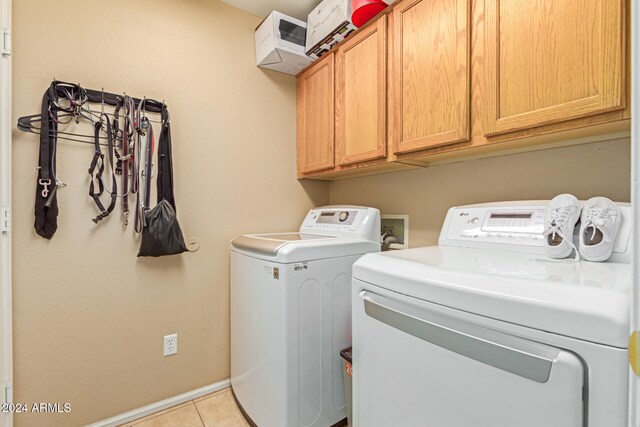 laundry room featuring cabinets, independent washer and dryer, and light tile patterned floors