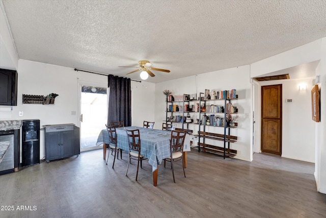 dining area with ceiling fan, a textured ceiling, and light wood finished floors