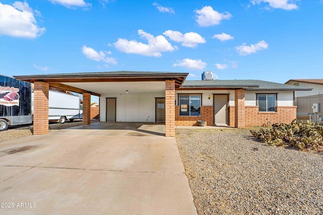 view of front of house with concrete driveway, a carport, and brick siding