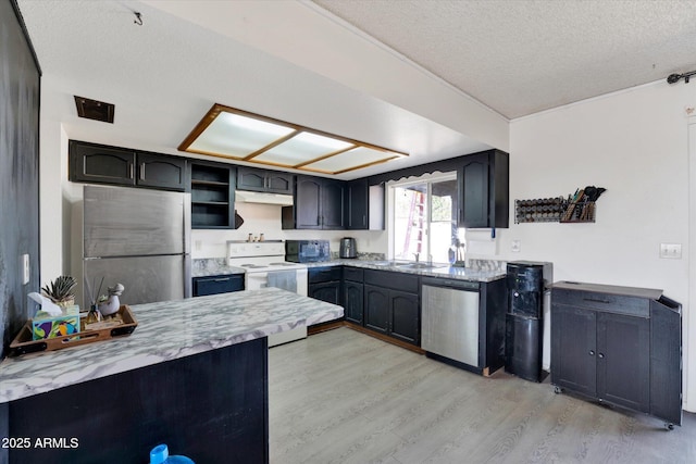 kitchen featuring a textured ceiling, light stone counters, under cabinet range hood, stainless steel appliances, and light wood-type flooring