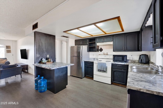 kitchen featuring white range with electric cooktop, freestanding refrigerator, under cabinet range hood, black microwave, and a sink