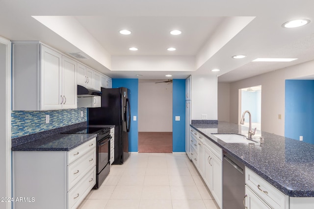 kitchen featuring black appliances, sink, dark stone countertops, white cabinetry, and kitchen peninsula