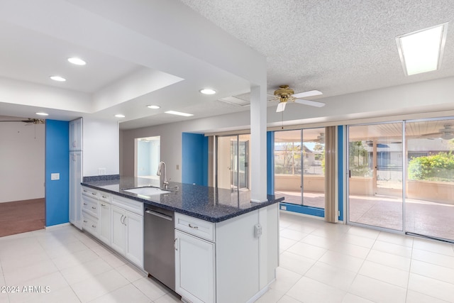 kitchen featuring ceiling fan, sink, dark stone countertops, dishwasher, and white cabinetry