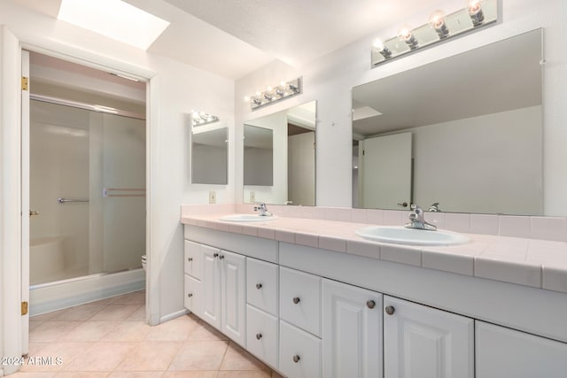 bathroom with toilet, a shower with door, vanity, and tile patterned flooring