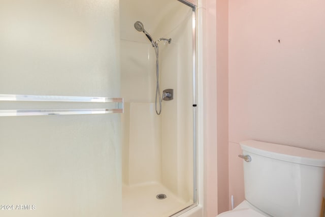 bathroom with toilet and a shower with shower door