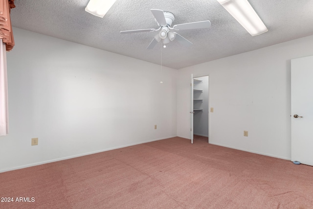 carpeted spare room with a textured ceiling and ceiling fan