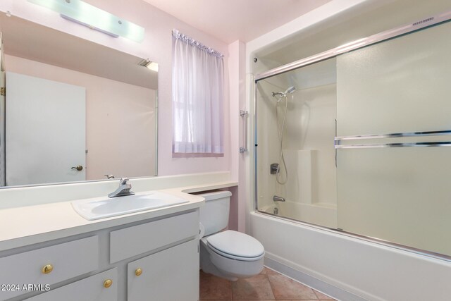 full bathroom featuring tile patterned flooring, vanity, toilet, and shower / bath combination with glass door