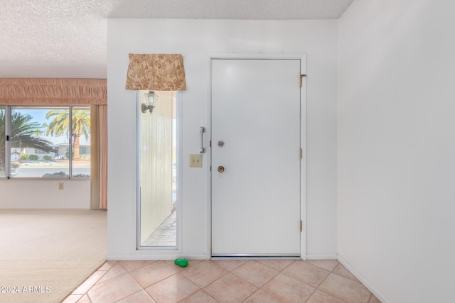 tiled entryway featuring a textured ceiling