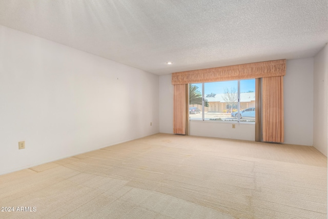 carpeted spare room featuring a textured ceiling