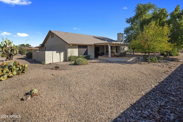 rear view of property featuring a pergola, a patio area, and a chimney