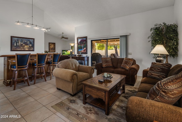 living room with ceiling fan, light tile patterned floors, a textured ceiling, and vaulted ceiling