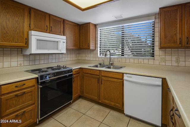 kitchen with light tile patterned flooring, white appliances, decorative backsplash, and sink