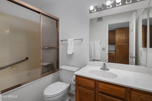 bathroom featuring visible vents, toilet, vanity, and bath / shower combo with glass door