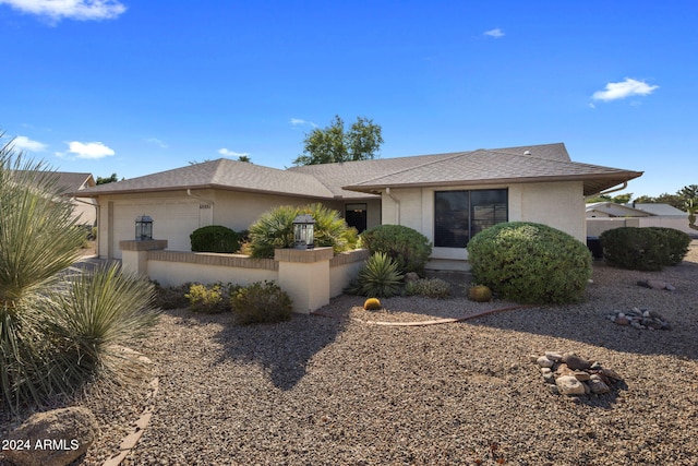 single story home featuring roof with shingles, a garage, and stucco siding