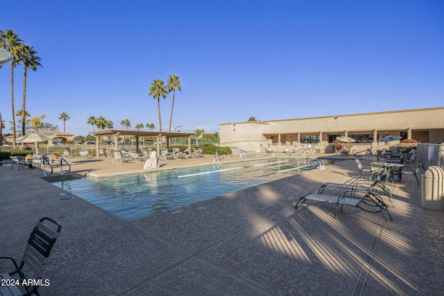 community pool featuring fence and a patio