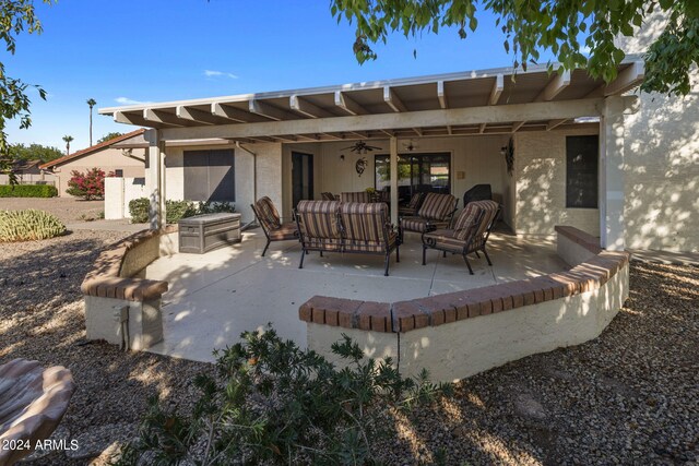 rear view of house with ceiling fan, an outdoor living space, and a patio