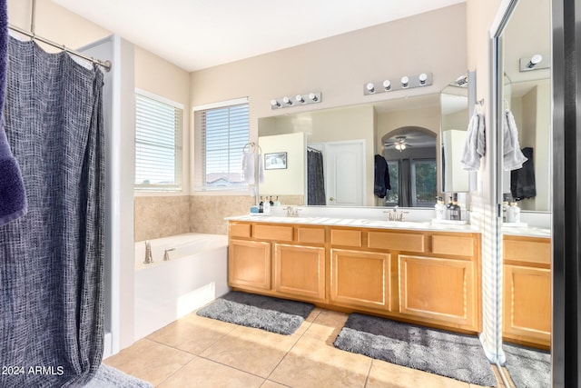 full bath featuring tile patterned floors, a bath, and double vanity