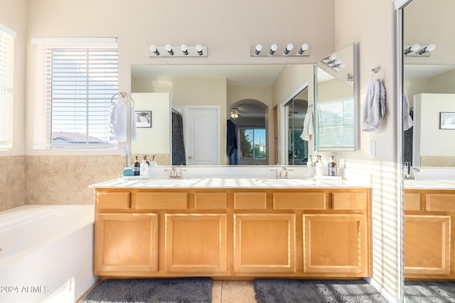 full bathroom featuring a bath, double vanity, and tile patterned floors