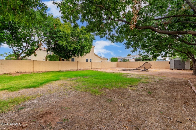 view of yard featuring a shed, fence, and an outdoor structure