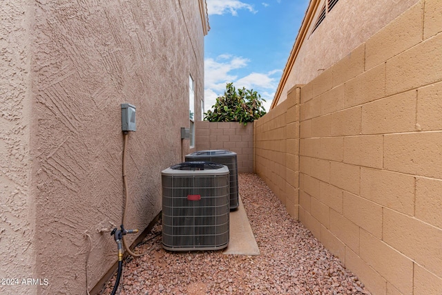 view of home's exterior featuring central air condition unit, fence, and stucco siding
