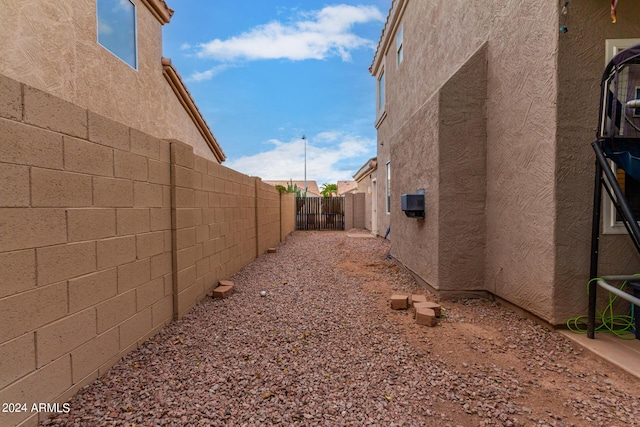 view of side of home with stucco siding and a fenced backyard