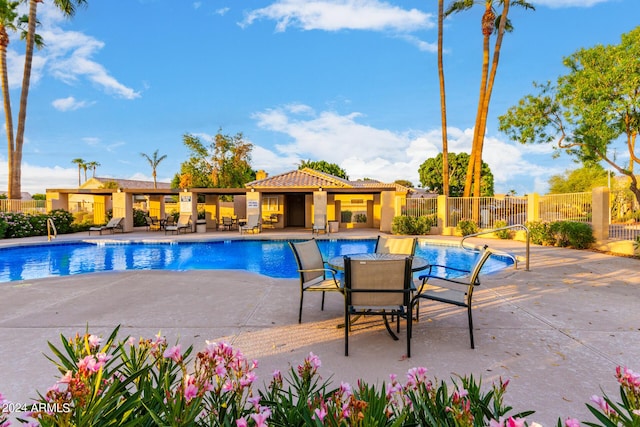 community pool with fence and a patio