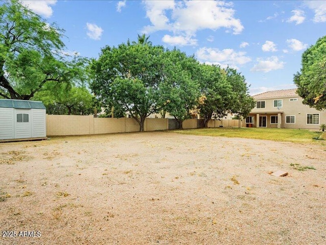 fenced backyard featuring a storage shed and an outdoor structure