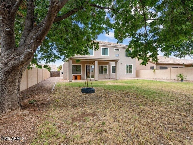 rear view of property with stucco siding, a tile roof, and a patio