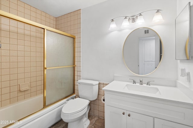 full bathroom featuring enclosed tub / shower combo, vanity, and toilet