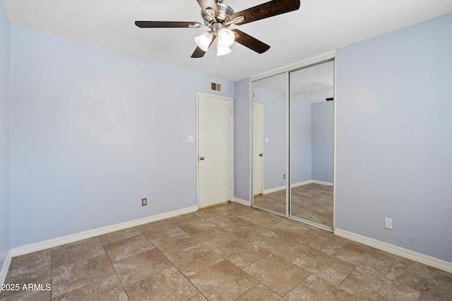 unfurnished bedroom with ceiling fan and a closet