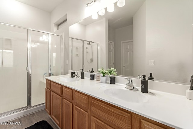 full bath featuring a sink, a stall shower, and double vanity