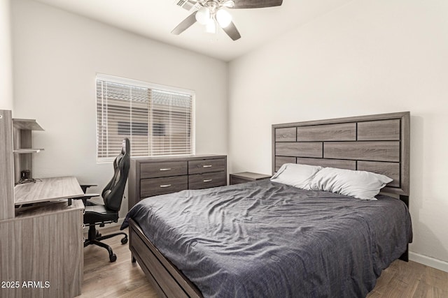 bedroom featuring baseboards, a ceiling fan, and wood finished floors