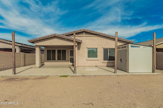 rear view of property featuring a fenced backyard, stucco siding, and a patio area