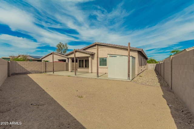 back of house with a patio, a fenced backyard, and stucco siding