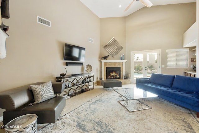 living room with carpet flooring, ceiling fan, french doors, high vaulted ceiling, and a fireplace