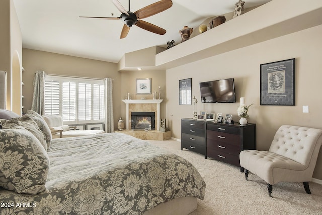 carpeted bedroom featuring ceiling fan, lofted ceiling, and a tiled fireplace