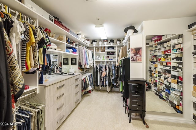 walk in closet with light carpet