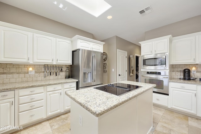 kitchen with white cabinets, appliances with stainless steel finishes, and light stone counters