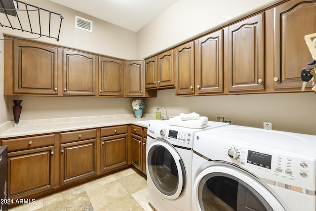 laundry room with cabinets, washer and dryer, and sink