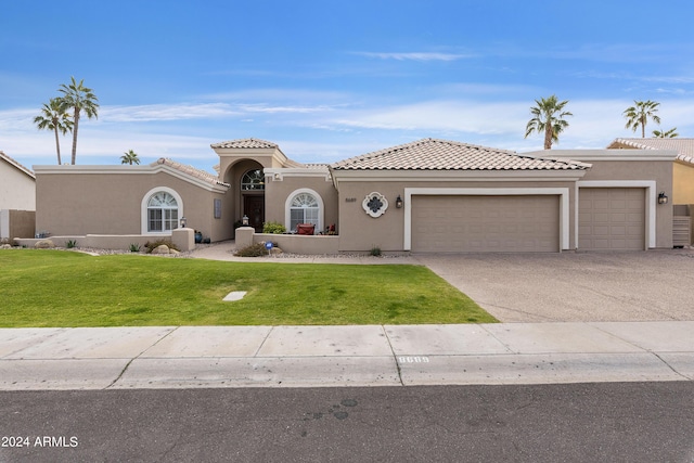 mediterranean / spanish house featuring a front yard and a garage