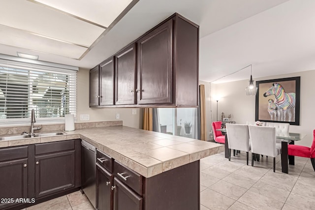 kitchen featuring dark brown cabinets, pendant lighting, and a sink