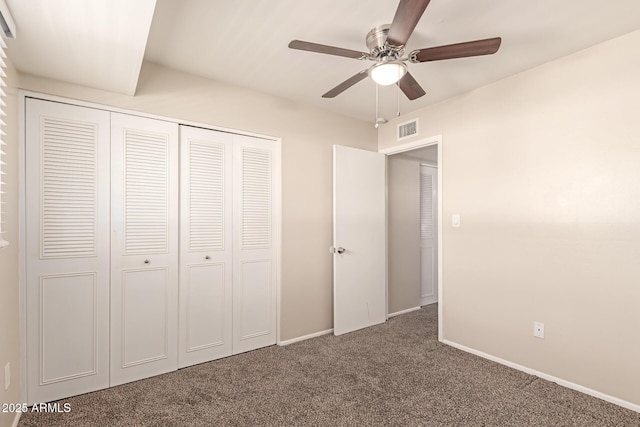 unfurnished bedroom featuring dark colored carpet, a closet, visible vents, and baseboards