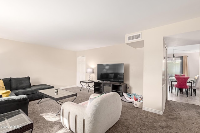 living area featuring visible vents, light carpet, and baseboards