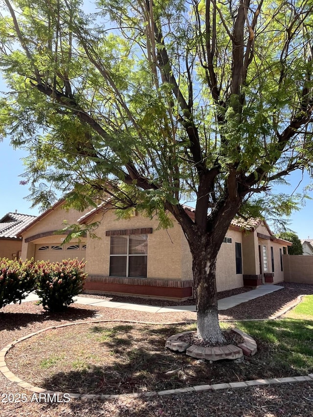 1827 E Carla Vista Dr, Gilbert, AZ 85295 - view of side of property featuring an attached garage, stucco siding, a tiled roof, and fence