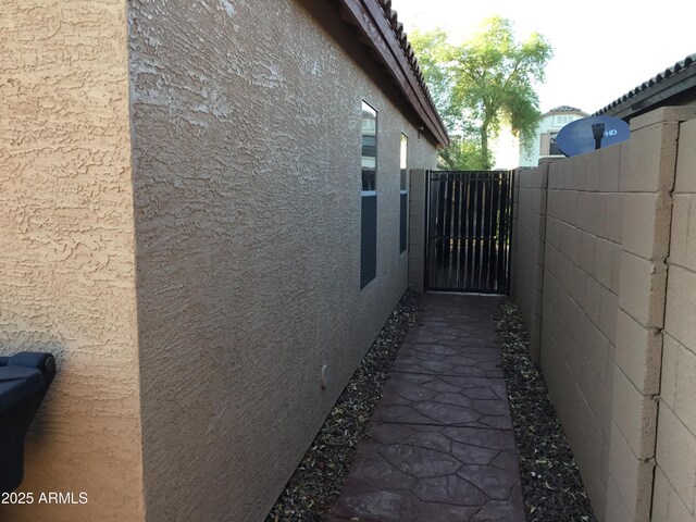 1827 E Carla Vista Dr, Gilbert, AZ 85295 - view of side of home featuring stucco siding, a gate, a tile roof, and fence